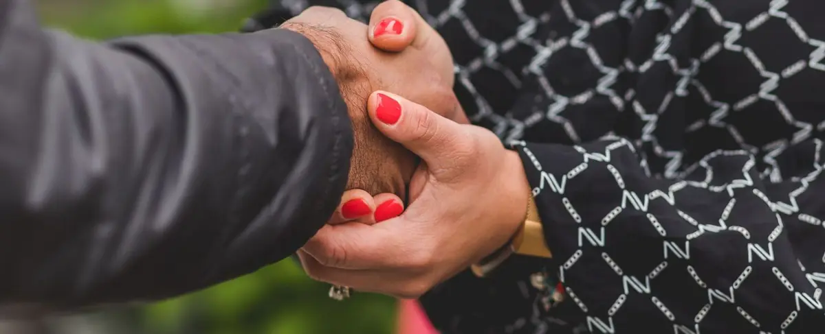 Two people shaking hands as keys are handed over
